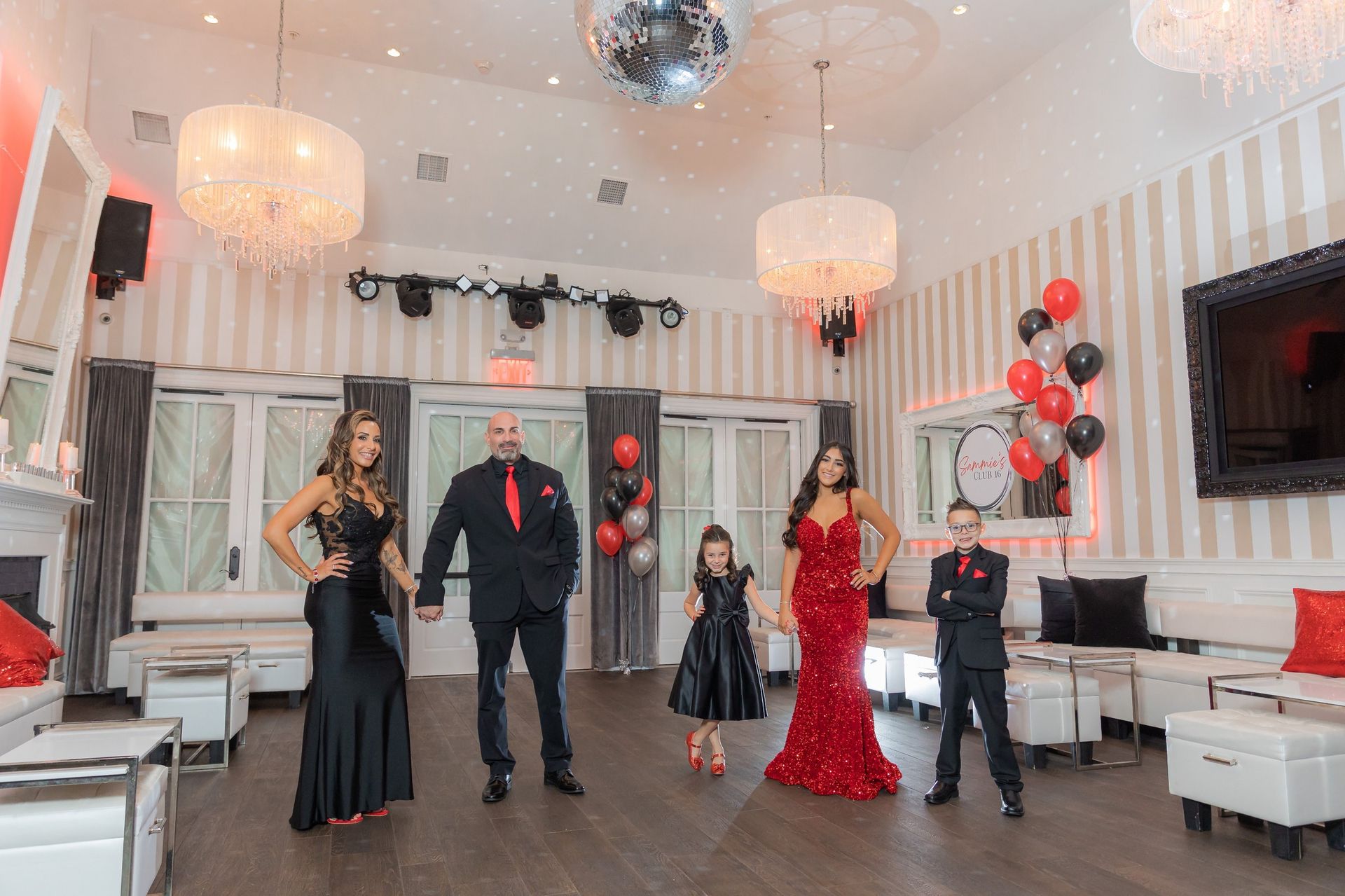 Sweet 16 celebrant in a red gown with her family at the reception