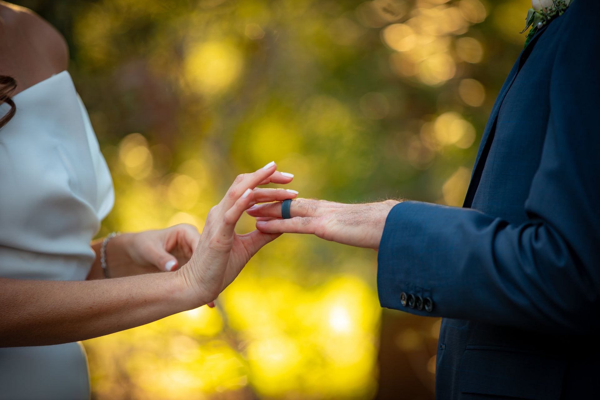 Couple exchanging rings during an outdoor wedding ceremony