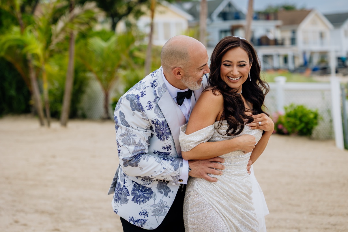 Newlyweds embracing beside palm trees at a tropical venue