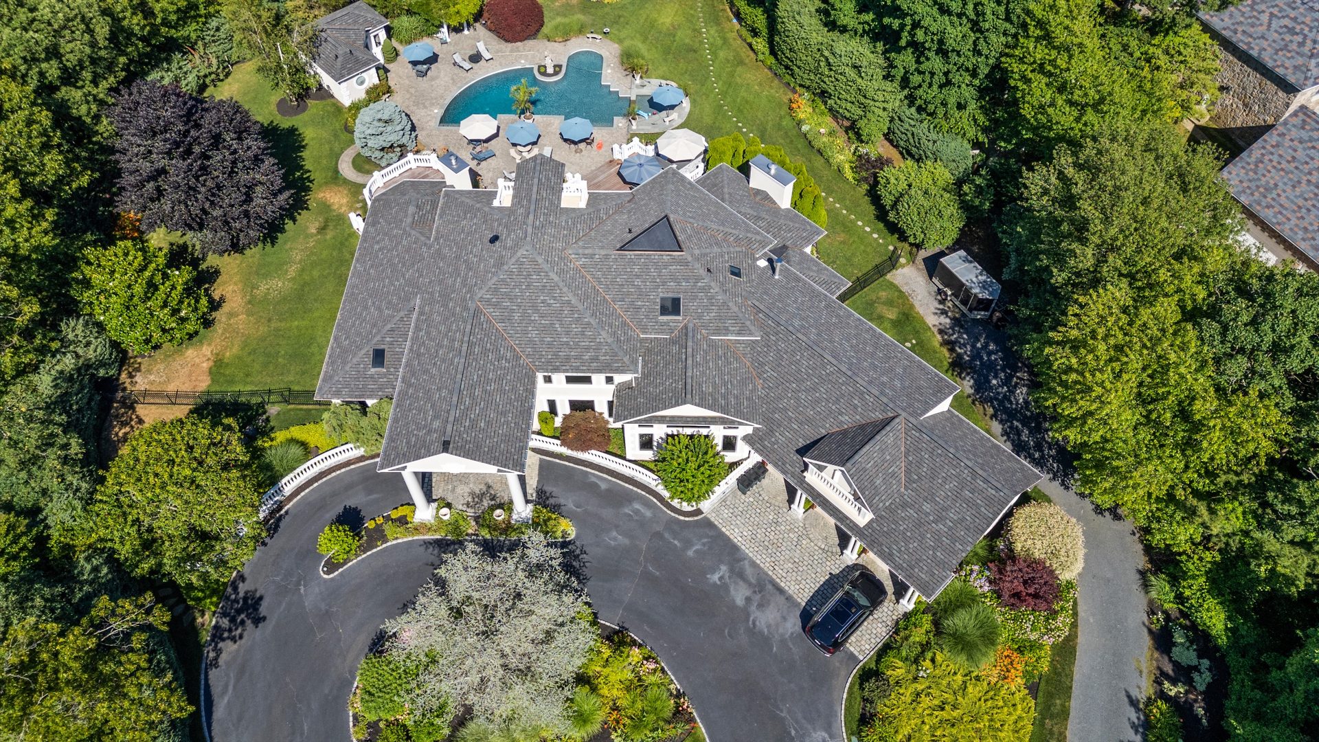 Aerial drone view of a luxury home with pool and landscaping